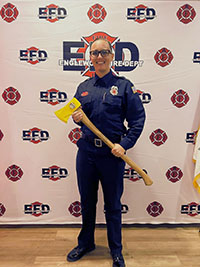 Jamie Wolfe in firefighter outpit, holding an ax